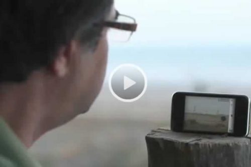 Still from the film Closed Curtain. Director Jafar Panahi looks at a film of the sea.