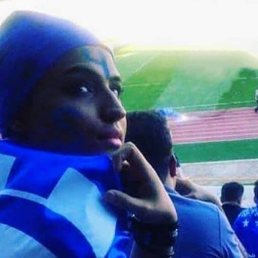 Sahar Khodayari at a soccer match with her face painted and a blue wig.